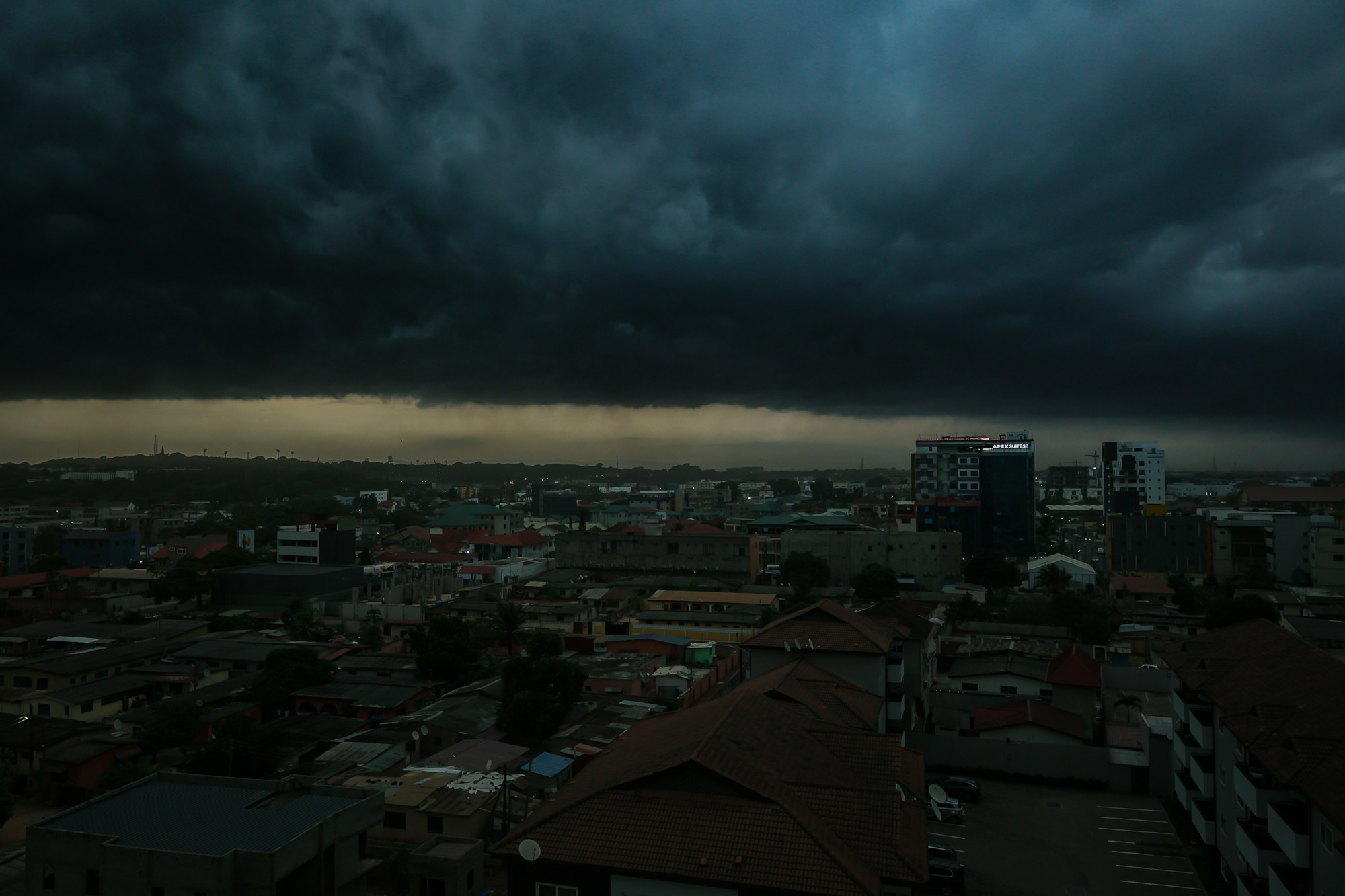Accra's skyline beneath dramatic rain clouds